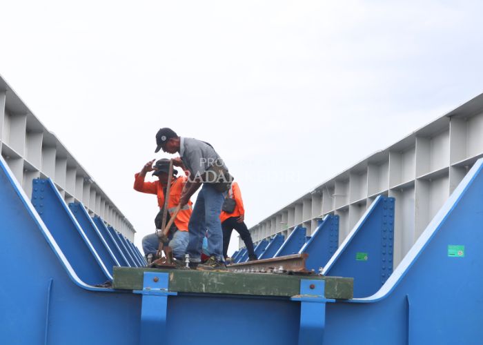 DIKEJAR WAKTU: Sejumlah pekerja menyiapkan gelagar jembatan perlintasan kereta api yang hari ini akan dipasang di Desa Jambean, Kras.