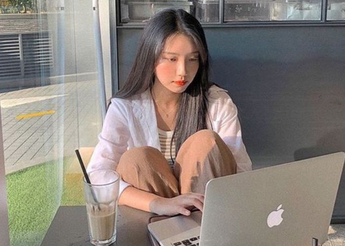 Ilustrasi seorang wanita terpapar sinar blue light saat bermain gadget.