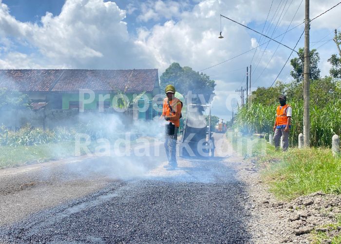 PERBAIKI KERUSAKAN: Pekerja dari Dinas PUPR menambal jalan berlubang di Desa Deyeng, Kecamatan Ringinrejo, Kabupaten Kediri.