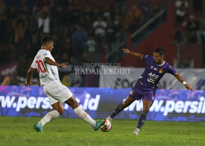 Striker Persik Kediri M. Khanafi beradu kaki dengan pemain Persis Solo.