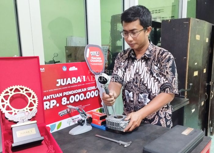 Rizky Arrohman memeriksa komponen mesin di ruang praktik engine teknik sepeda motor SMK Al Huda Kota Kediri, Jumat (142).