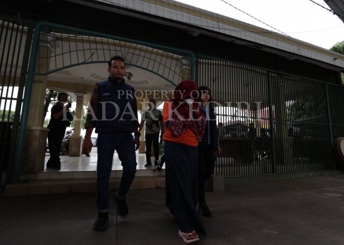 SIAP SIDANG: Anik berjalan menunduk saat di Polres Kediri.