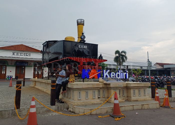 TIKET LUDES: Warga berfoto di depan lokomoyof di KA Kediri. Transportasi kereta api masih jadi idola saat mudik lebaran nanti.