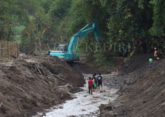 BANJIR LAGI: Anak-anak di Desa Pranggang, Ploklaten bermain di kali yang sedang dikeruk alat berat.