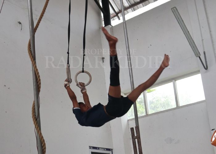 BERGELANTUNG: Atlet senam artistik saat latihan di gedung serba guna di Kelurahan/Kecamatan Mojoroto.