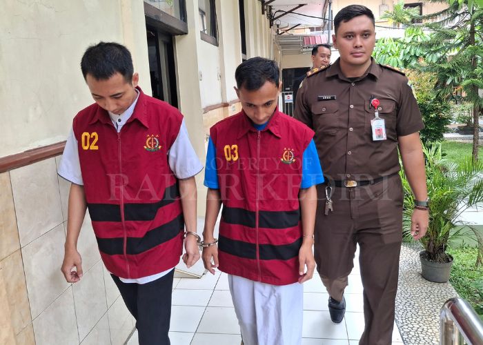 MENUNDUK: Terdakwa perampok minimarket dikawal petugas kejaksaan usai menjalani sidang di PN Kabupaten Kediri.