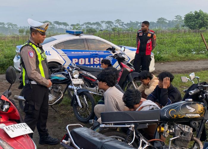TERTIBKAN BALAP LIAR: Anggota Satlantas Polres Kediri memberikan arahan dan sosialisasi keselamatan berkendara kepada pelaku balap liar di Desa Manggis, Kecamatan Puncu.