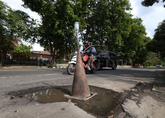 AWAS: Warga memasang tanda tanda jalan berlubang yang membahayakan pengendara di Kota Kediri.