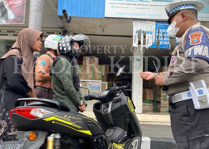 KENA TILANG: Polisi menghentikan pengendara bermotor yang tidak menggunakan helm saat melintas di Jalan Dhoho, Kelurahan Pakelan, Kota Kediri,