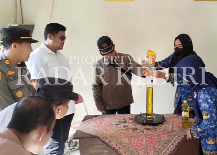 SIDAK: Tim lapangan disdagin menuangkan minyakita ke dalam takaran disaksikan Satreskrim Kediri Kota.