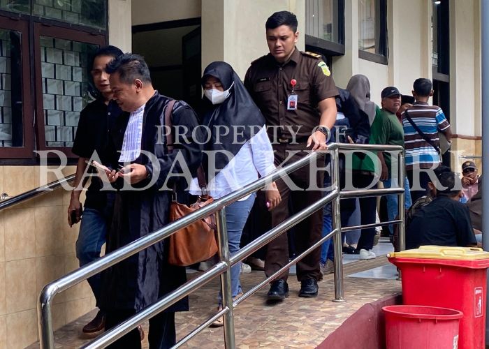 SIDANG PERDANA: Terdakwa Anik bersama dengan pengasihat hukumnya keluar dari ruang Cakra Pengadilan Negeri Kabupaten Kediri.