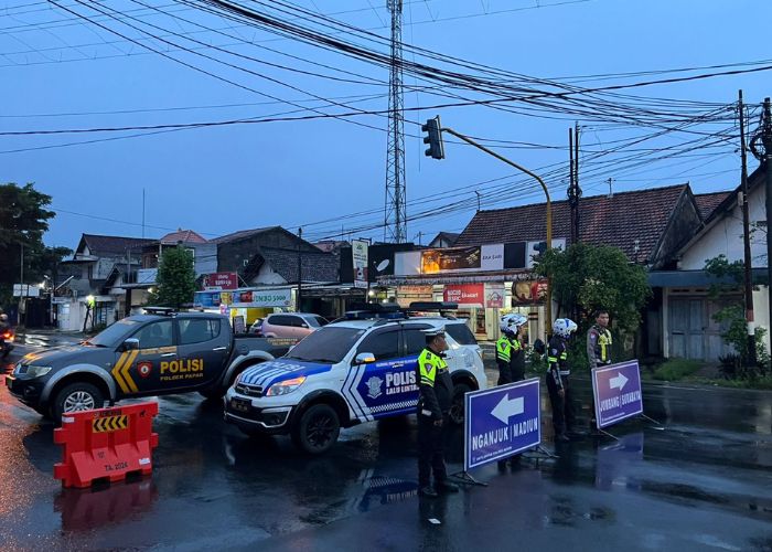 PENGALIHAN ARUS: Anggota Satlantas Polres Kediri mengatur lalu lintas di perempatan Papar. Penjagaan akan diperketat selama arus mudik Lebaran.