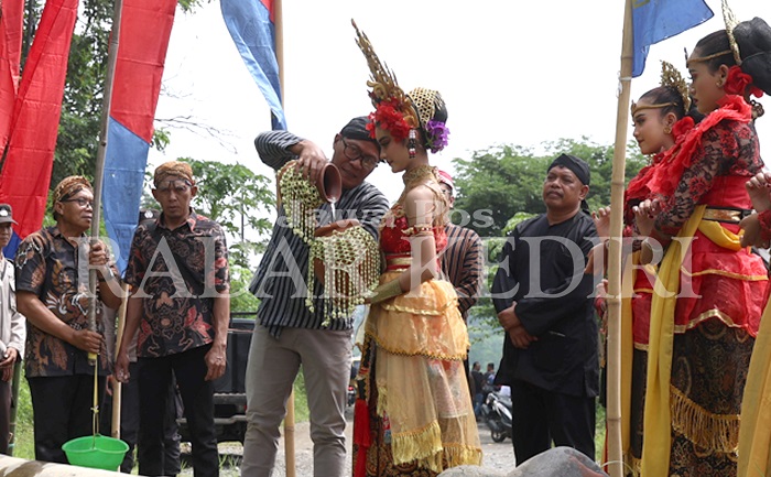 Kades Siman Subagiyo menuangkan air dari Sungai Harinjing.