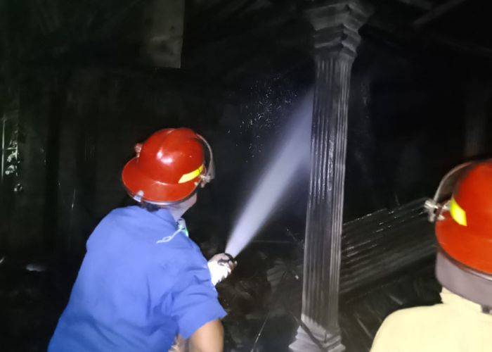 KERJA KERAS: Petugas Damkar Pos Pare menyemprotkan api ke kandang sapi yag terbakar.