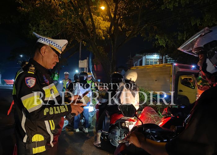 KENA RAZIA: Polisi memeriksa surat kendaraan pengendara motor yang terjaring operasi.