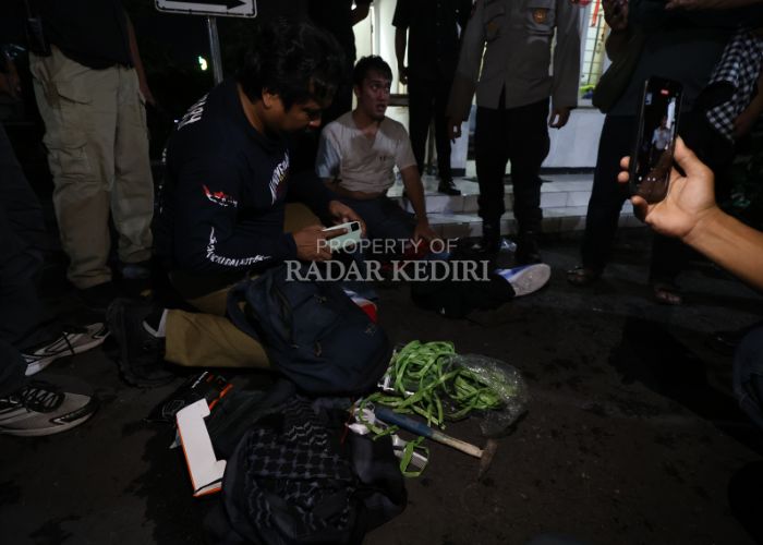 Petugas mengamankan dan memeriksa salah satu demonstran.