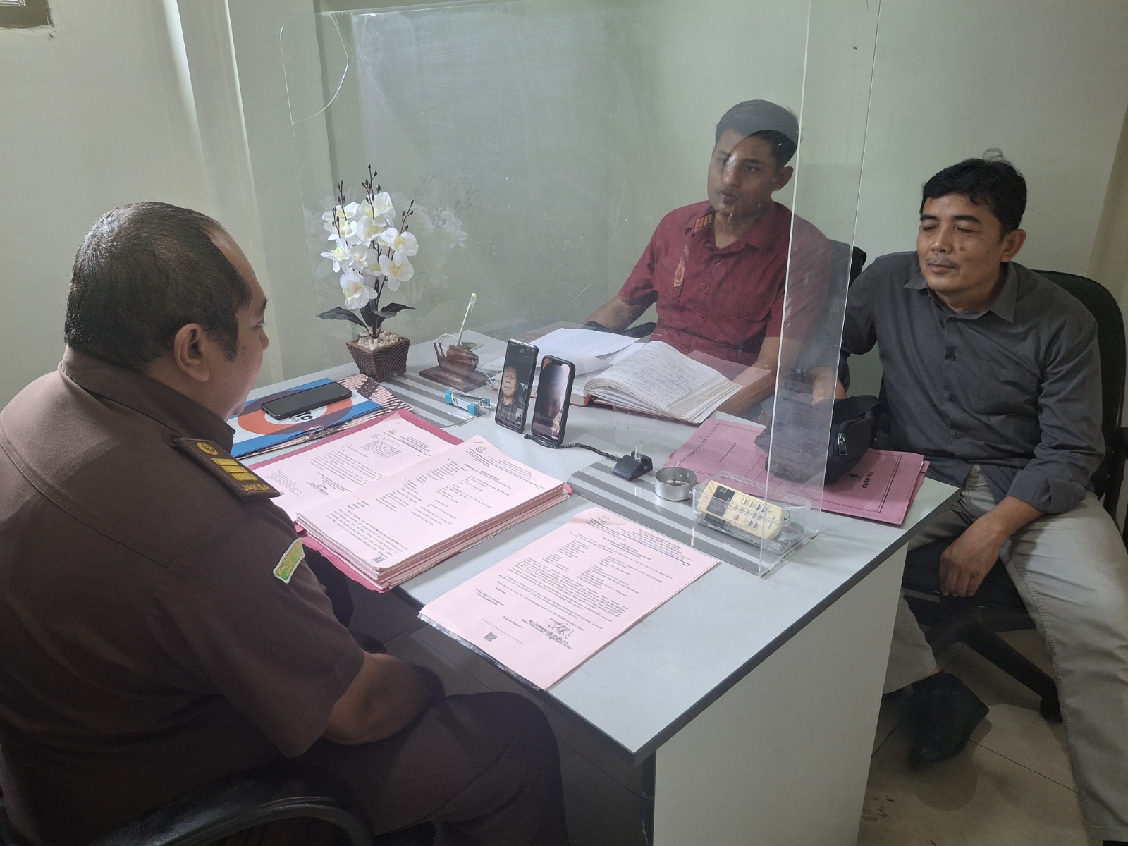 Jaksa memeriksa berkas perkara Yusa lewat sambungan video call. Berkas tersebut diserahkan langsung oleh dua penyidik kepolisian.