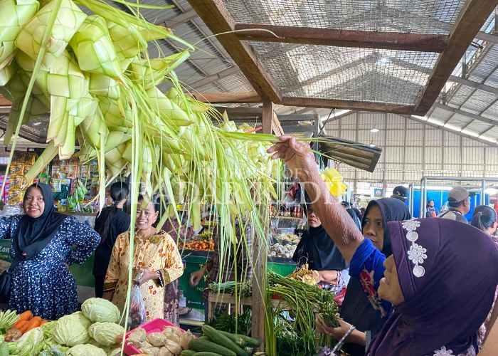 JAGA TRADISI: Seorang pembeli di Pasar Kras mencari ketupat untuk persiapan Lebaran pada 8 Syawal.