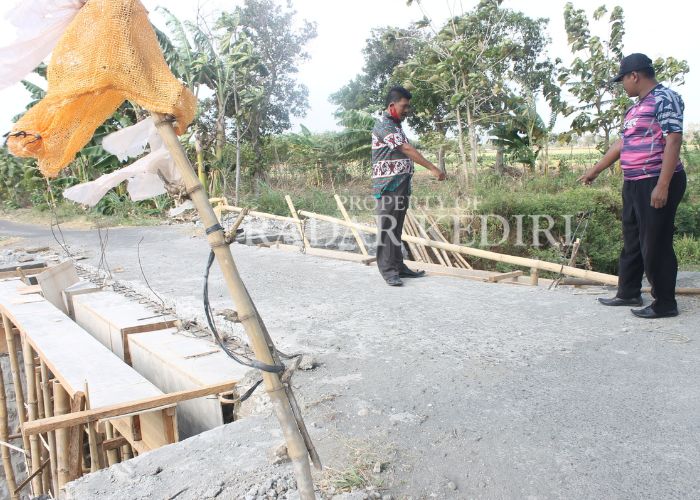 MELAYANI MASYARAKAT: Pemdes Bakalan saat berada di jembatan yang aksesnya sedang diperlebar.