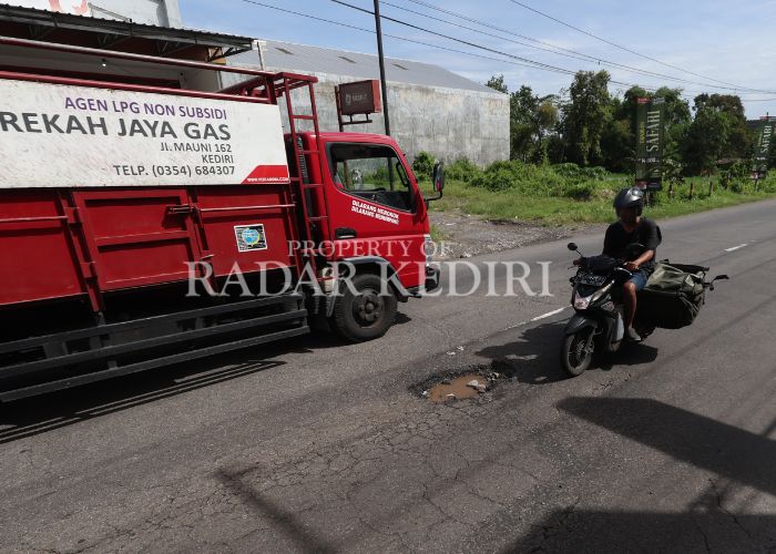 AWAS LUBANG Pengendara bermotor nyaris masuk jalan berlubang di Desa Tugurejo, Kecamatan Ngasem.