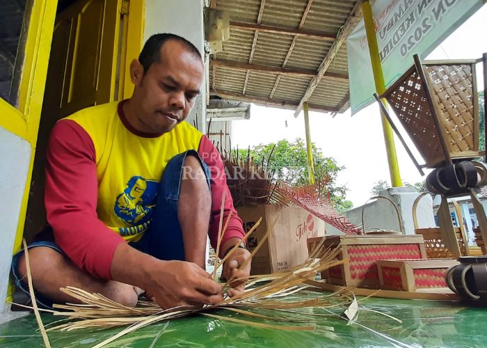 Sutikno menganyam bambu jadi kerajinan tangan.