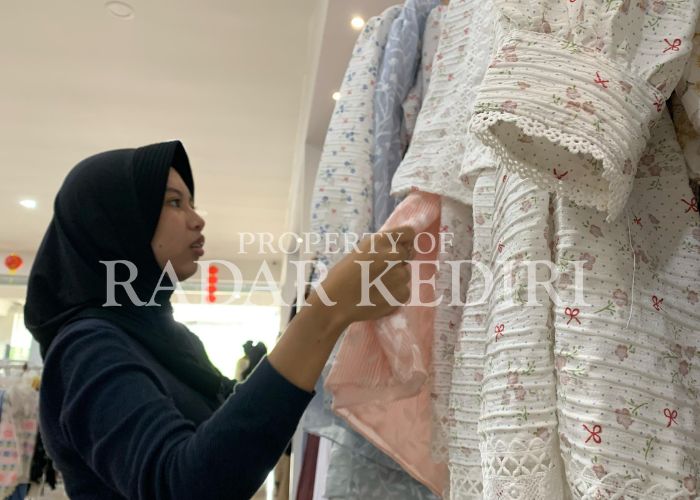 TREN FASHION: Seorang pembeli sedang memilih pakaian di toko baju.