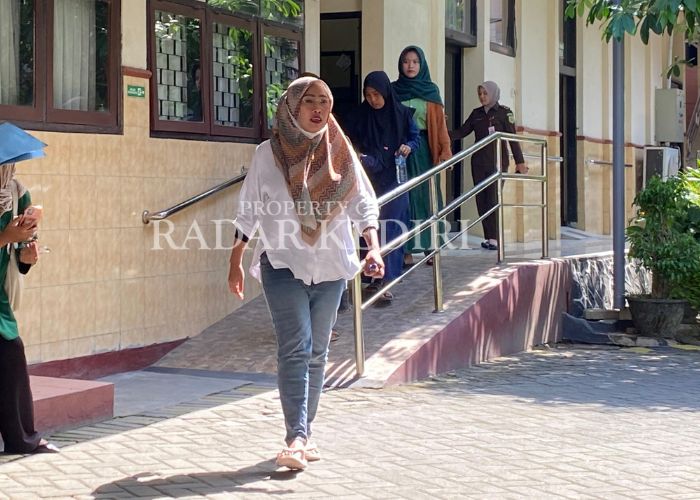 SIDANG LANJUTAN: Terdakwa Anik keluar dari ruang Cakra di PN Kabupaten Kediri usai mendengarkan keterangan saksi yang masih anak-anak.