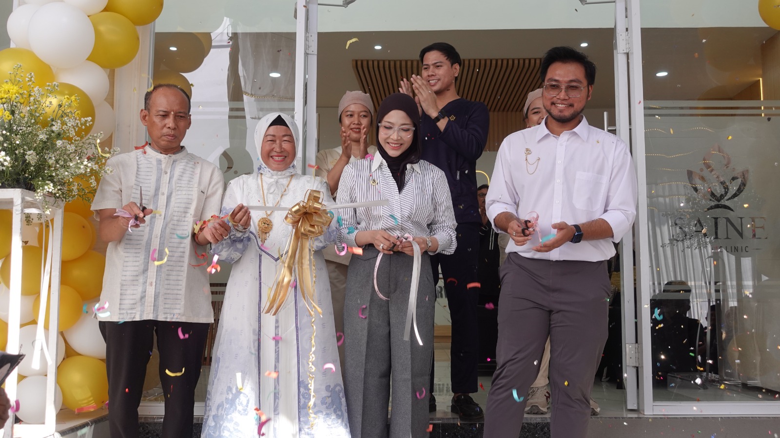Owner Saine Skin Clinic dr Fiemel didampingi suami dan keluarga memotong pita sebagai simbol grand opening.