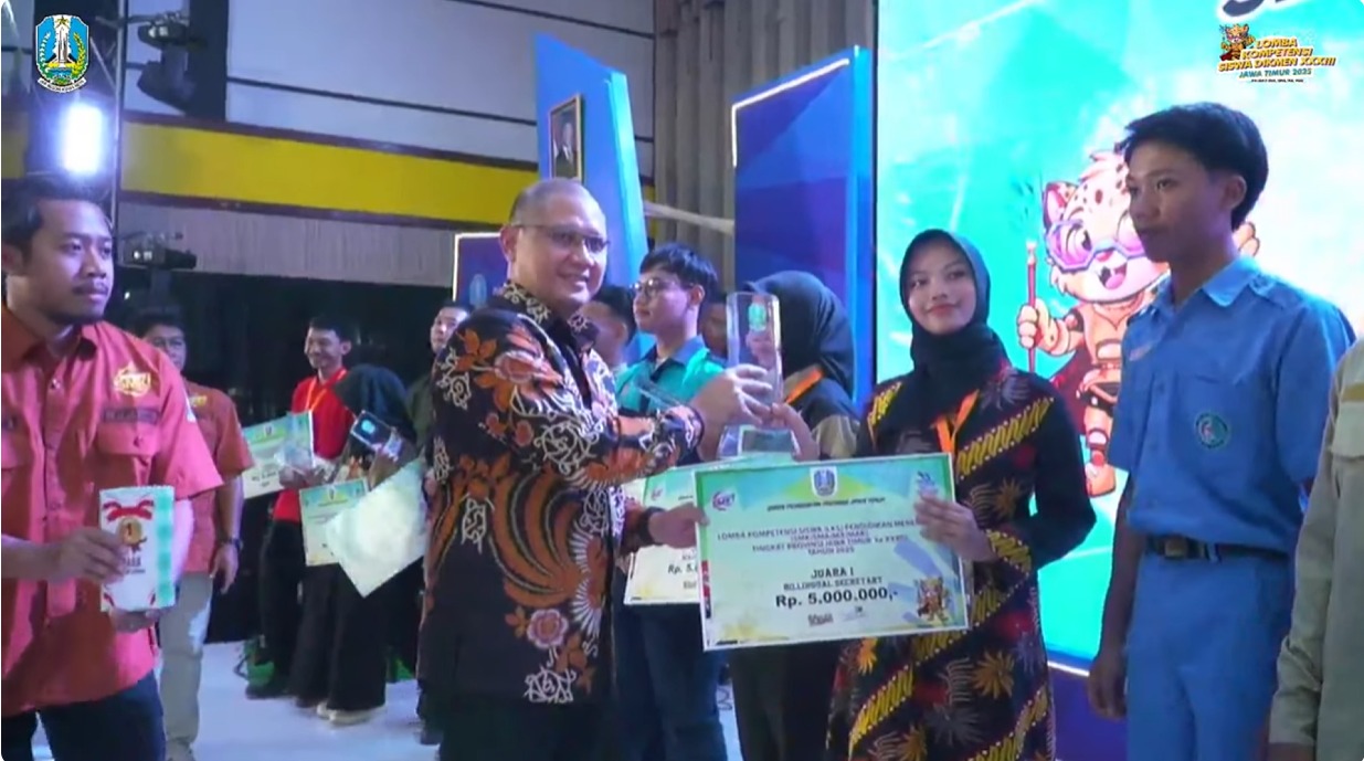 Kadisdik Provinsi Jatim Aries Agung Paewai memberikan piala kepada Putri Aisyah Bilhaq yang menjadi juara 1 lomba Bilingual Secretary.