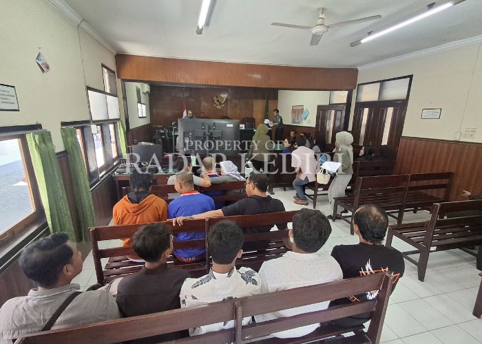 MENANGIS:Terdakwa didampingi keluarga saat menunggu giliran sidang di Pengadilan Negeri Kabupaten Kediri.