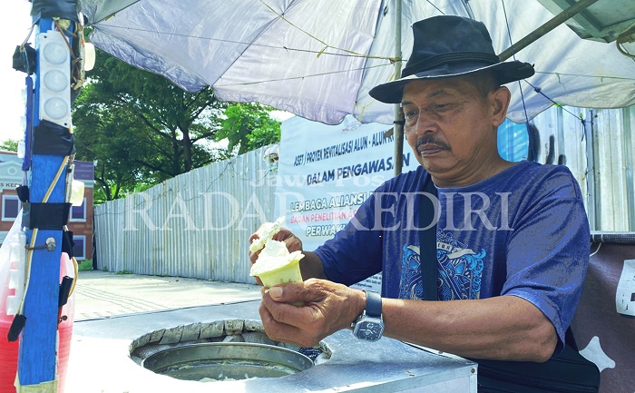 Sarjito melayani pembeli es puter di rombongnya (1/5). Sejak akhir April dia dipusingkan harga bahan baku kelapa yang mahal.