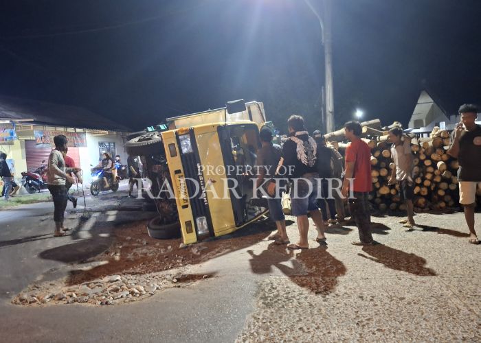 TERGULING: Truk bermuatan kayu sengon ambruk menimpa pagar Polsek Wates.