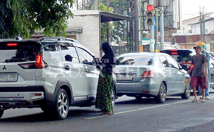 Seorang pengemis yang membawa bayi meminta uang kepada pengendara kendaraan di simpang empat Jl Ahmad Dahlan kemarin. Praktik mengemis membawa bayi merupakan tindakan eksploitasi anak.