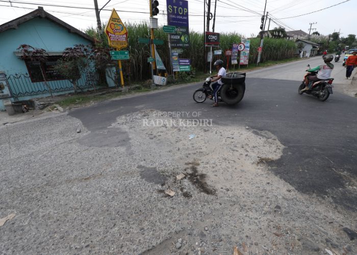 BERBAHAYA: Pengendara melintasi simpang tiga Polsek Wates yang mengalami rusak berat. Rencananya, ruas tersebut akan diperbaiki bulan depan.