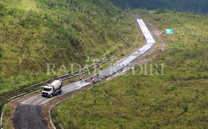 Sejumlah pekerja melakukan pengecoran jalan di puncak gunung Kelud. Sedikitnya jalan rusak sepanjang 240 meter akses menuju kawah itu diperbaiki dan ditarget bisa tuntas minggu ini.