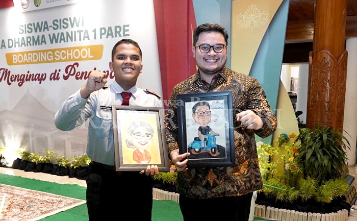 Bupati Kediri Hanindhito Himawan Pramana tak menyangka menerima karikatur dirinya dan Eriani Annisa, sang istri, dari siswa SMA Dharma Wanita Boarding School.