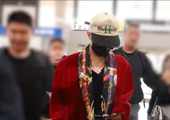 G-Dragon saat tiba di Bandara internasioanl Gimpo dengan mengenakan jubah mandi berwarna merah