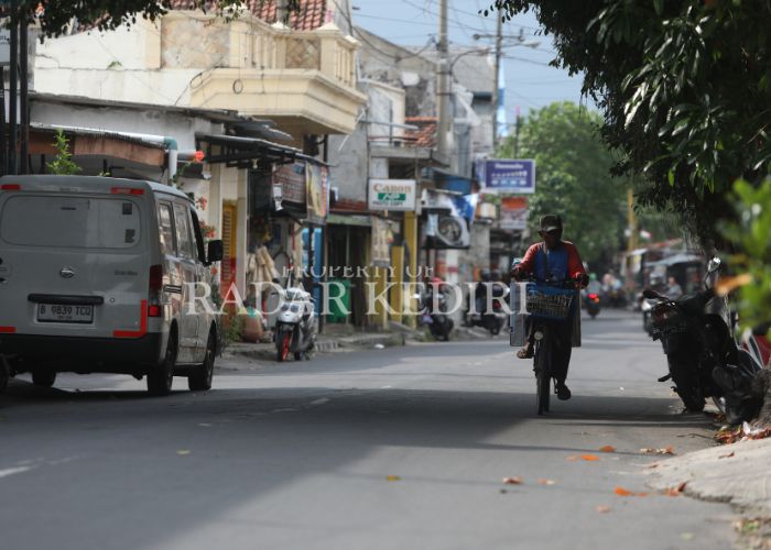 PENCAIRAN BANSOS: Seorang warga mengayuh sepeda di wilayah Kota Kediri.