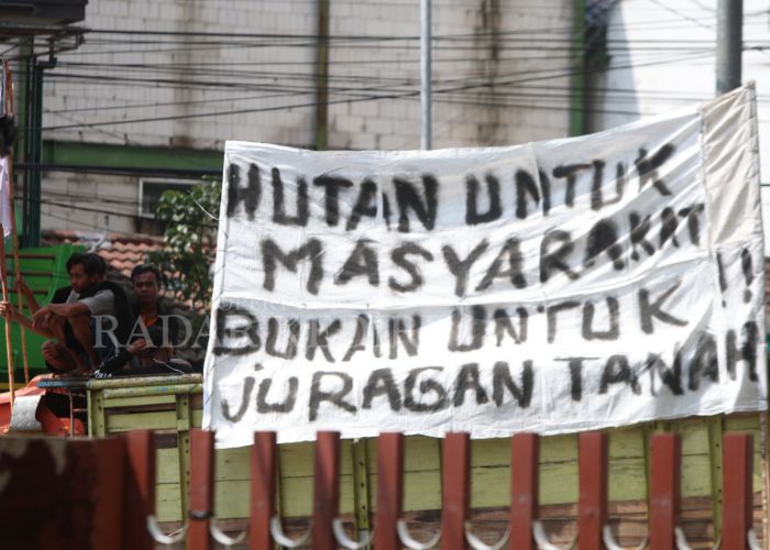 MINTA HAK KELOLA TANAH: Warga Manggis membentangkan spanduk bernada protes setelah