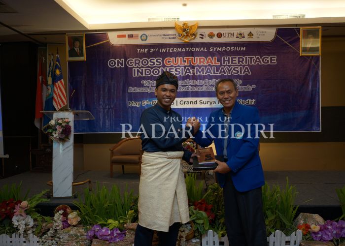 LINTAS NEGARA: Rektor UNP Kediri Zainal Afandi salam komando dengan perwakilan negara Malaysia saat simposium internasional.