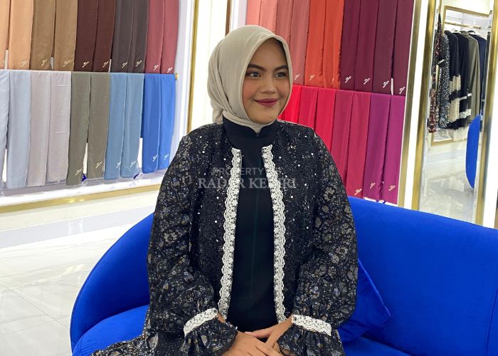 Model menggunakan pakaian bermotif floral.
