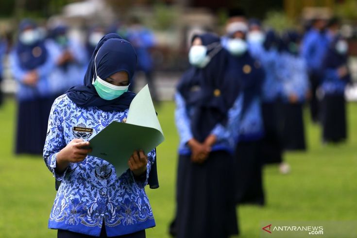 Seorang guru sedang mengecek berkas dokumen yang dibawa.