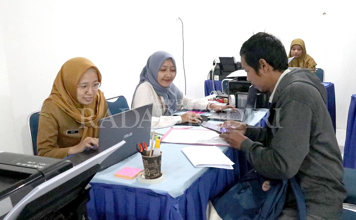 Operator Dinas Pendidikan Kota Kediri membantu orang tua siswa yang kesulitan saat mendaftar di jenjang TK, SD, dan SMP Kota Kediri.