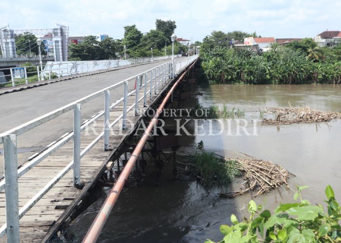 CAGAR BUDAYA: Petugas sedang membersihkan sampah yang menumpuk di Jembatan Lama Kota Kediri.