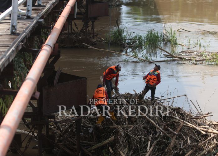 BERSIH-BERSIH: Tim BPBD Kota Kediri mengurai sampah yang tersangkut di Jembatan Lama Kota Kediri.