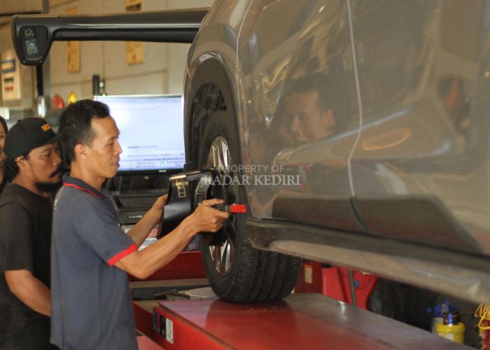 Teknisi sedang mengerjakan proses spooring di Sinar Ban Kediri.