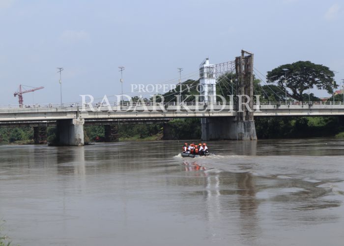 PEMBERSIHAN SAMPAH: Petugas lapangan meninjau kaki jembatan lama yang menumpuk dengan sampah.