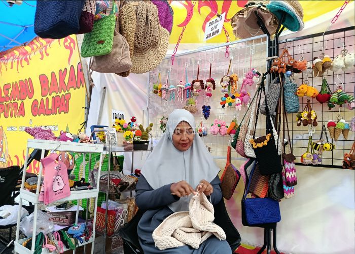 Swasti mengerjakan rajutan di stan Kuno Kini.