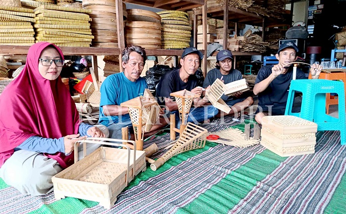 Dian Etika Putri bersama empat karyawan tengah memproduksi  kerajinan bambu, di rumahnya, di Desa Kerkep, Kecamatan Gurah.