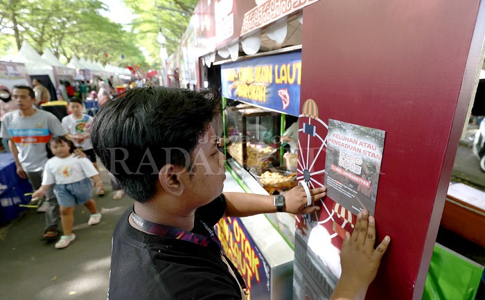 Panitia memasang stiker terkait pengaduan stan atau pedagang di area Festival Kuno-Kini. Ajang pameran terbesar di Kediri Raya itu masih akan berlangsung hingga 1 Juni dengan berbagai jenis dagangan.